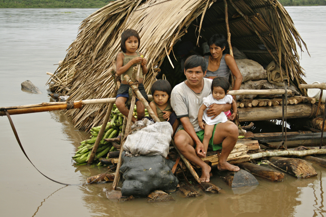Amazon River family on a trading voyage down-river, Peru