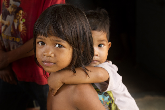 Cambodian girl carrying her baby brother